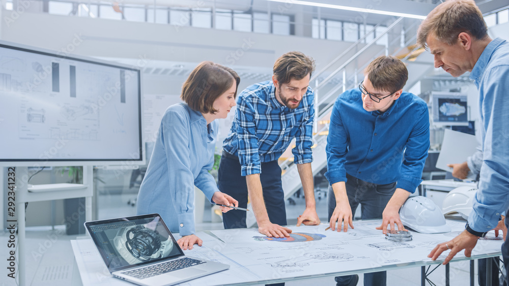 Engineering team reviewing drawings at a shared table