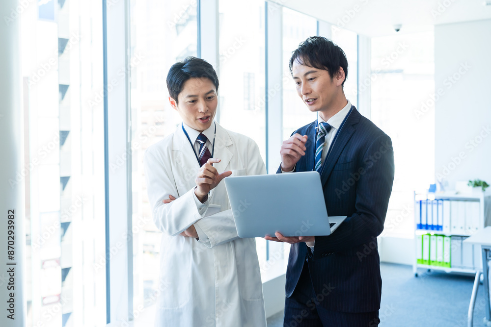 Two colleagues reviewing data on a laptop in a laboratory